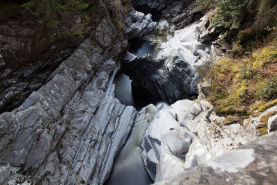 High angle view of stream amidst rock formations during winter