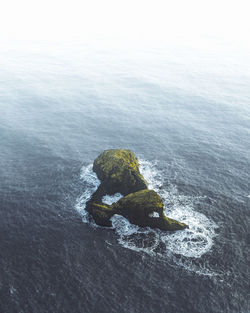 Aerial view of rock formation amidst sea