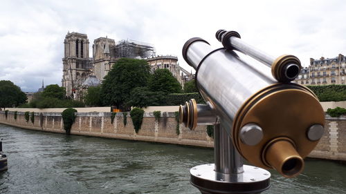 View of  cathedral by river against cloudy sky