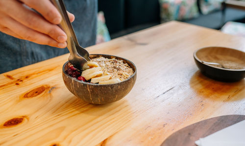 Cropped hand of person preparing food on table