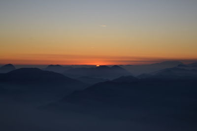 Scenic view of silhouette mountains against sky at sunset