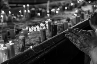 Midsection of person holding illuminated candles in temple