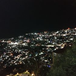 Illuminated cityscape against clear sky at night