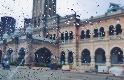 Cars on road seen through wet window in rainy season