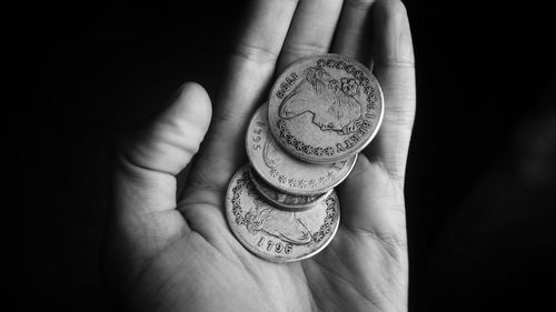 Close-up of hand holding coins