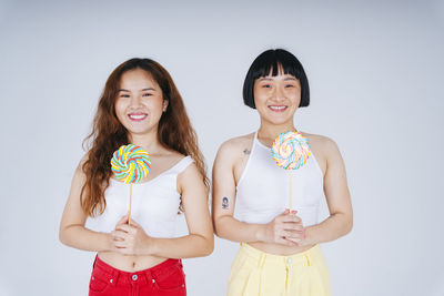 Portrait of smiling young woman against white background