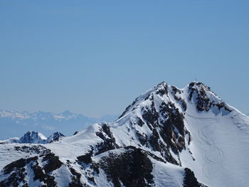 Scenic view of snowcapped mountains against clear blue sky