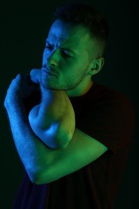 Portrait of young man against black background