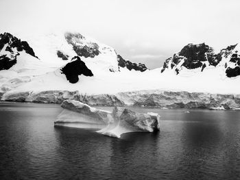 Black and white photo of iceberg with mountains and glacier 