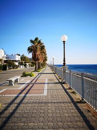 Street by sea against clear sky