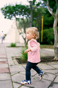 Full length of boy standing on footpath