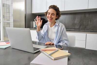 Portrait of young businesswoman using digital tablet while standing in office