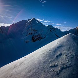 Scenic view of snowcapped mountains against blue sky