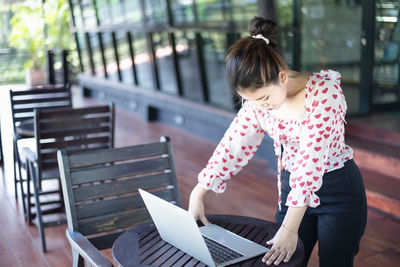 Young woman using laptop at park