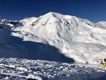 Scenic view of snowcapped mountains against clear sky