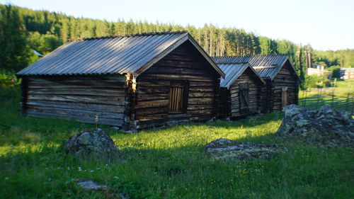 Wooden house on field against sky