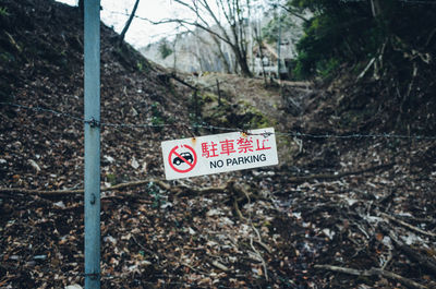 Road sign by trees in forest