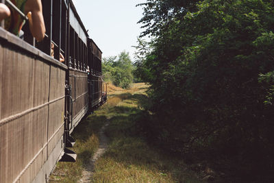 Train on road amidst trees against clear sky