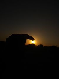 Close-up of silhouette mountain against clear sky during sunset