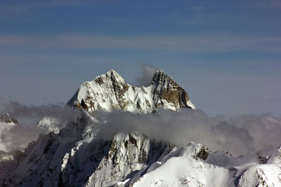 Scenic view of snow covered mountains against sky