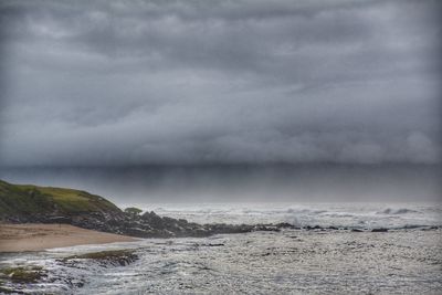 Scenic view of sea against storm clouds