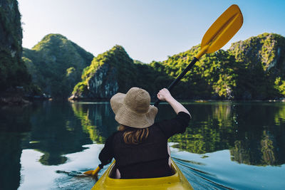 Rear view of woman kayaking in lake