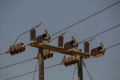 Low angle view of electricity pylon against sky