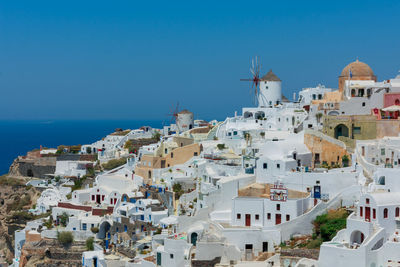 Townscape by sea against blue sky