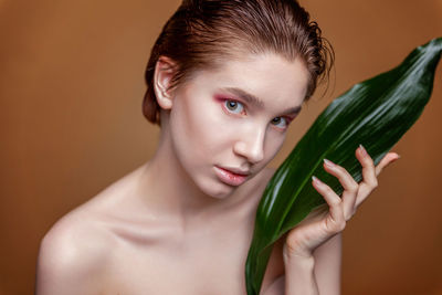 Side view of young woman holding plant