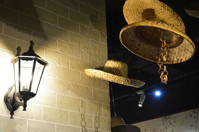Low angle view of illuminated lamp hanging on wall