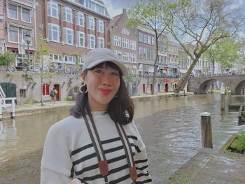 Portrait of young woman standing in canal