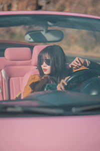 Portrait of young woman in car