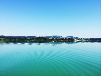 Calm blue sea against clear sky