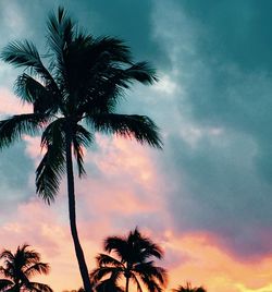 Low angle view of silhouette palm trees against romantic sky