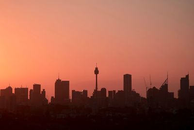 Silhouette of buildings in city during sunset