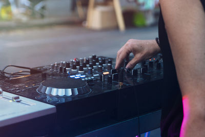 Midsection of man using sound mixer while standing outdoors