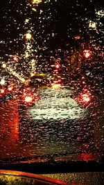 Full frame shot of wet car on road at night