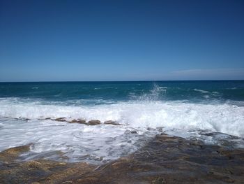 Scenic view of sea against clear blue sky