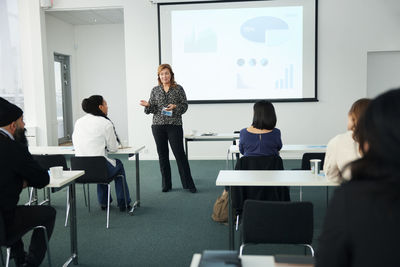 Businesswoman presenting before colleagues during meeting