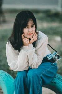 Portrait of smiling young woman sitting outdoors