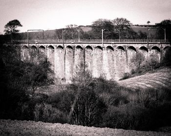 Arch bridge over river against sky