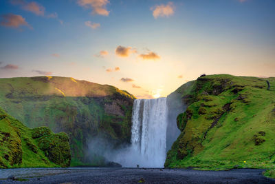 Scenic view of waterfall against sky