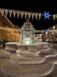 Statue of illuminated building at night