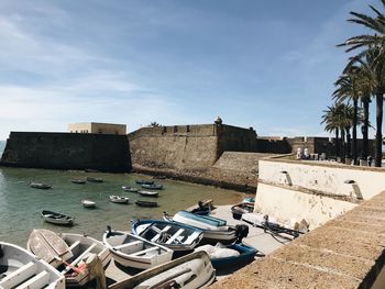 Boats moored by sea against sky