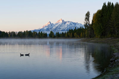 Scenic view of lake by mountains against sky