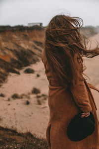 Side view of woman holding hat