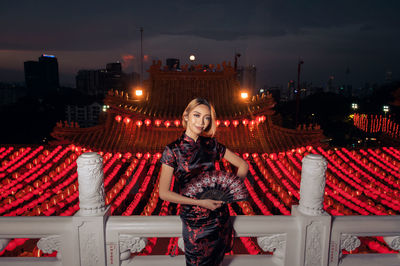 Portrait of young woman in city during chinese lantern festival at night