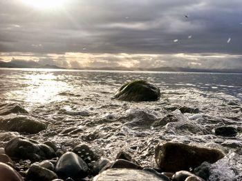 Close-up of sea against sky during sunset