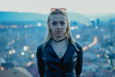 Portrait of young woman standing against sky