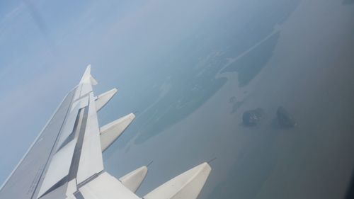 High angle view of airplane wing against sky